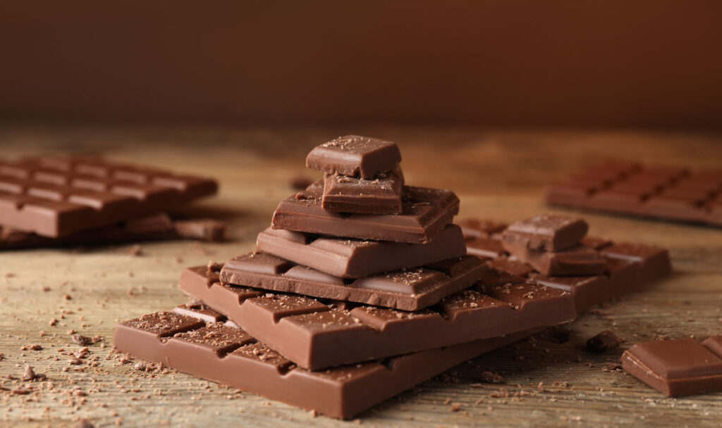 Pieces and crumbs of tasty chocolate on wooden table
Schokolade, Schoko-Tafel, Braun, Genuss